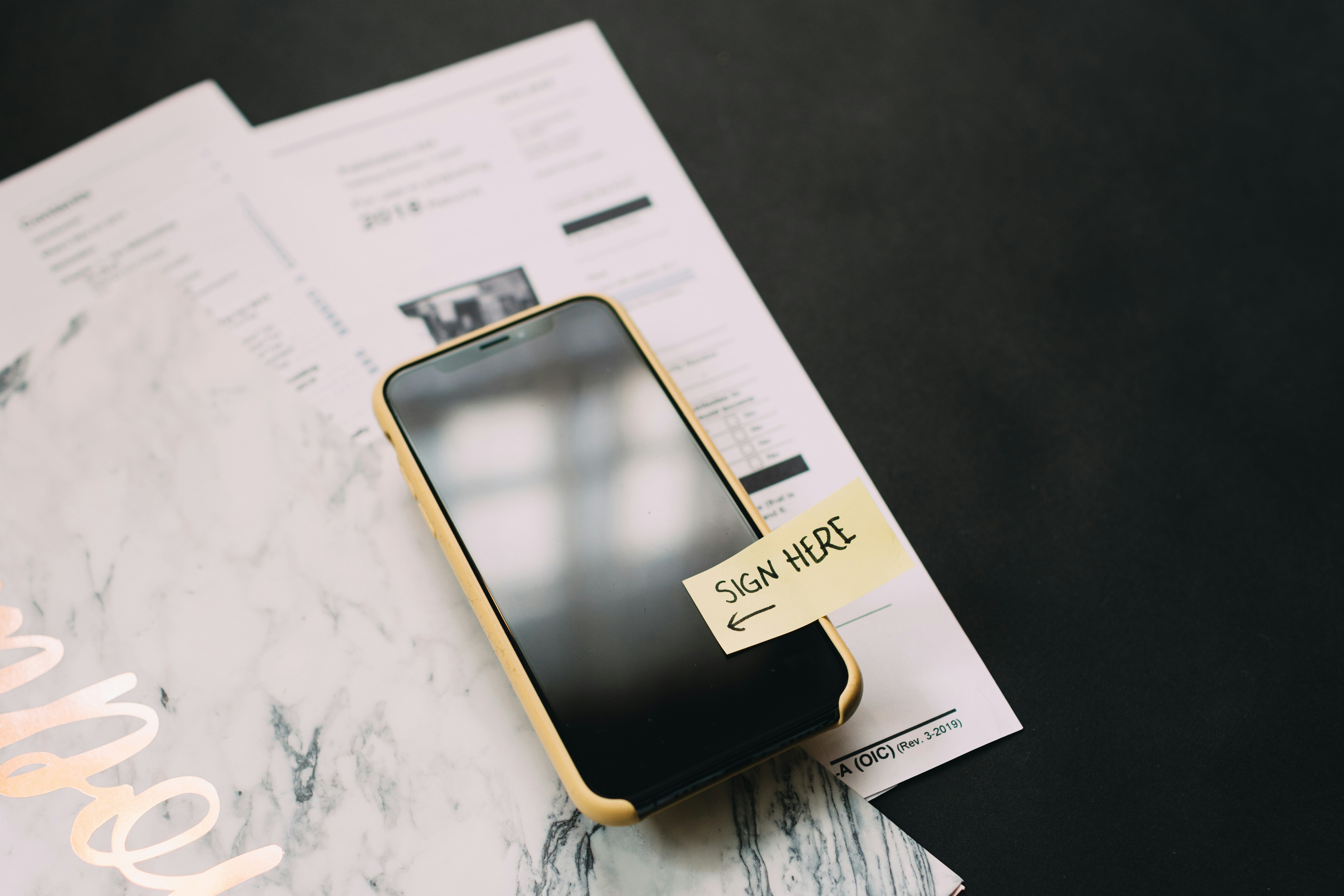 A phone sitting on top of some paperwork