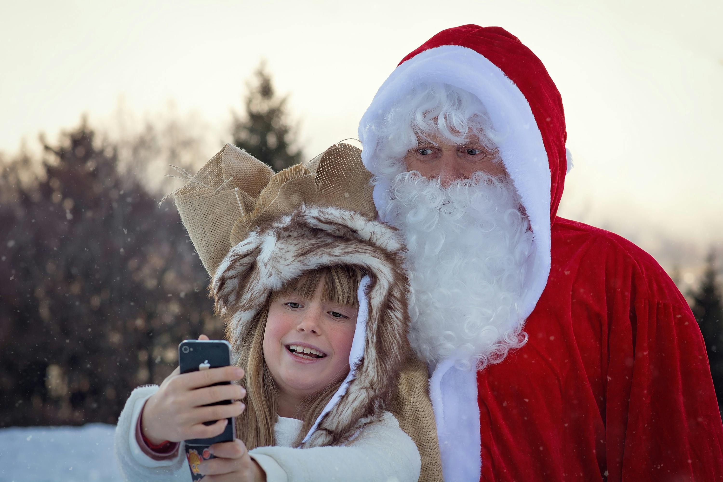 A photo of Santa taking a selfie with a pre-teen.